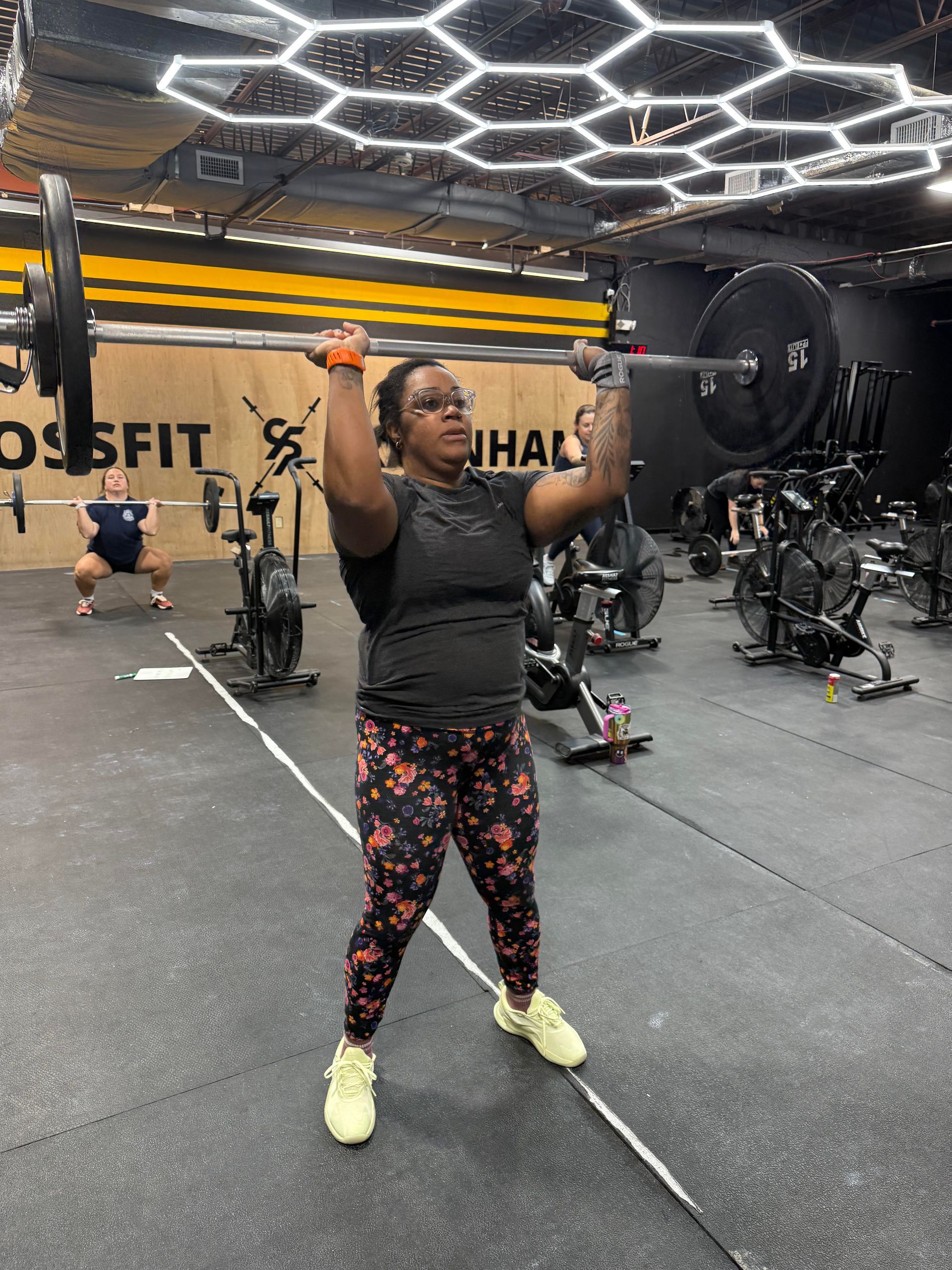 a woman is jumping over a box in a gym .