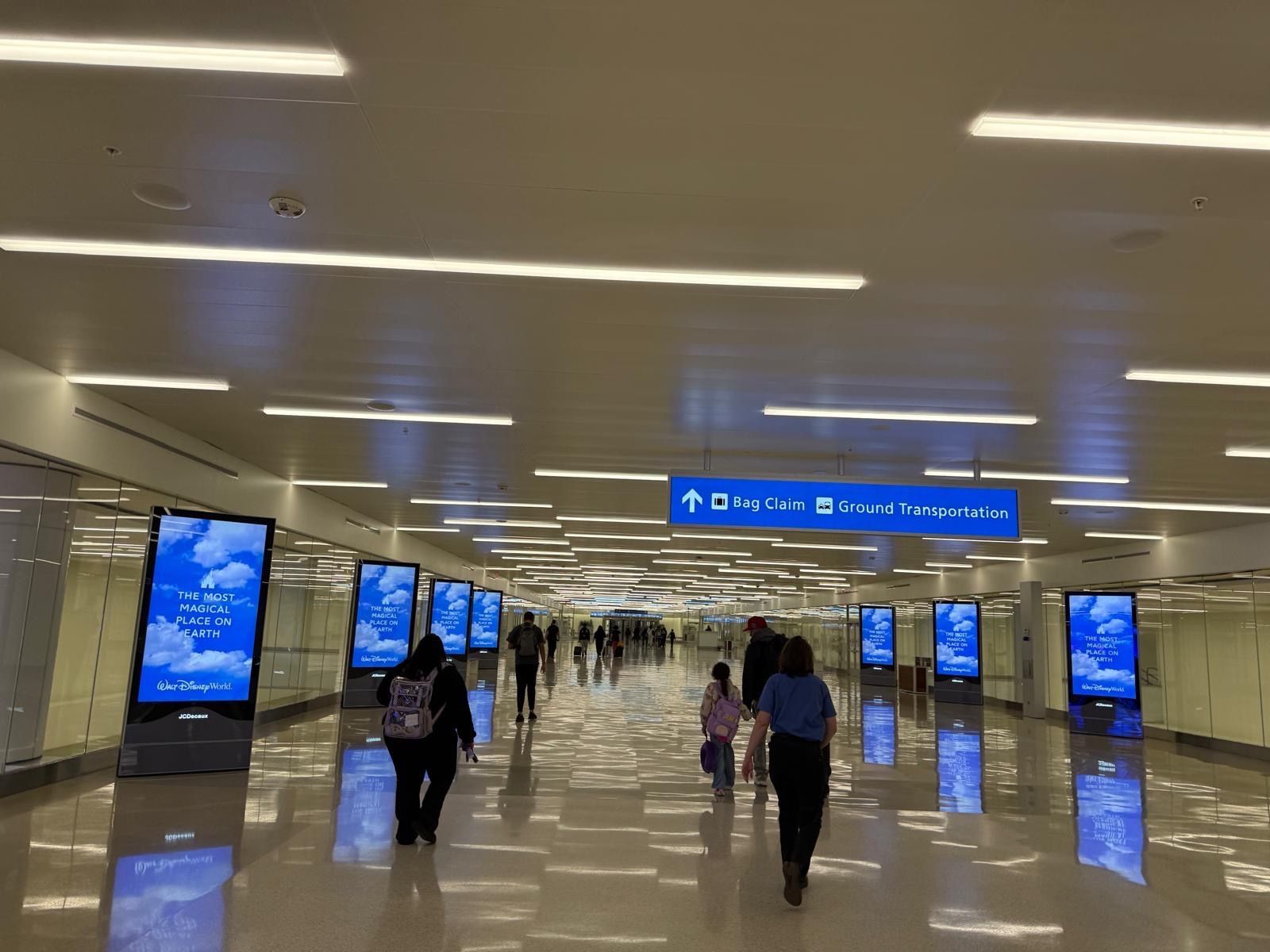 A group of people are walking through an airport terminal.