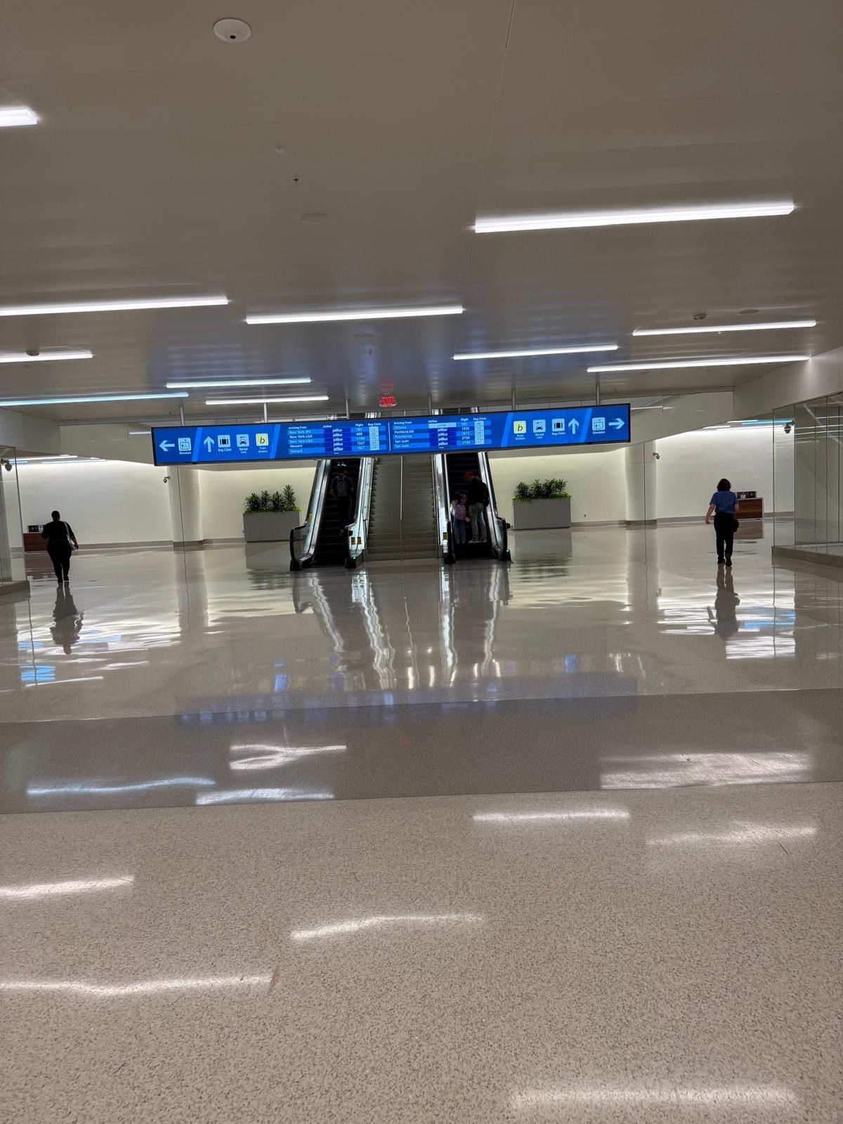 A person is walking down an escalator in an airport