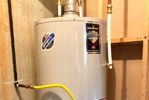 A water heater is attached to a wall in a room.