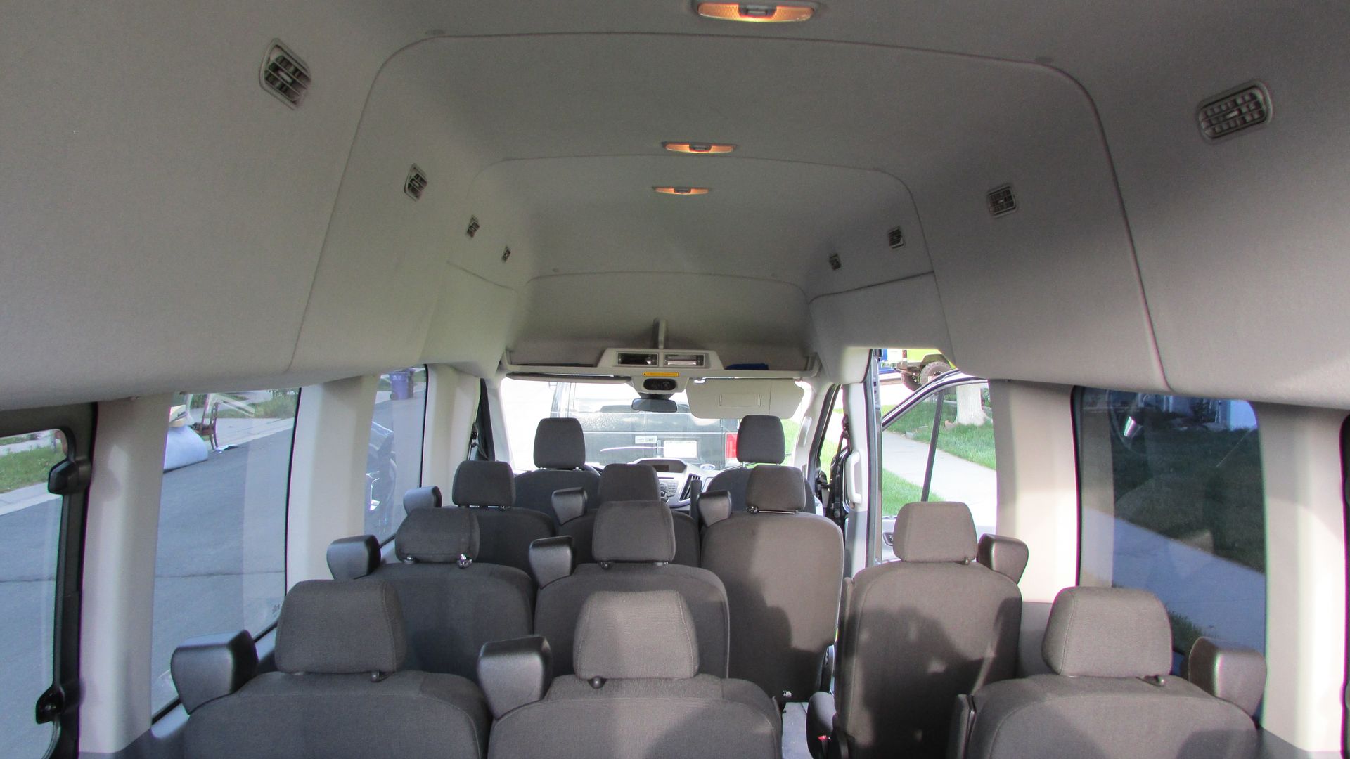 The inside of a van with a lot of seats and a lot of windows.