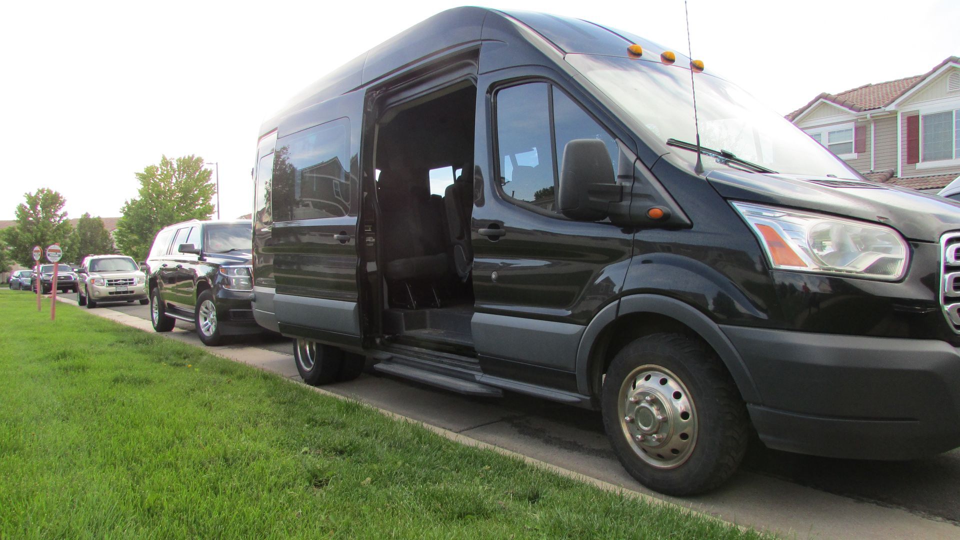 A black van is parked on the side of the road.
