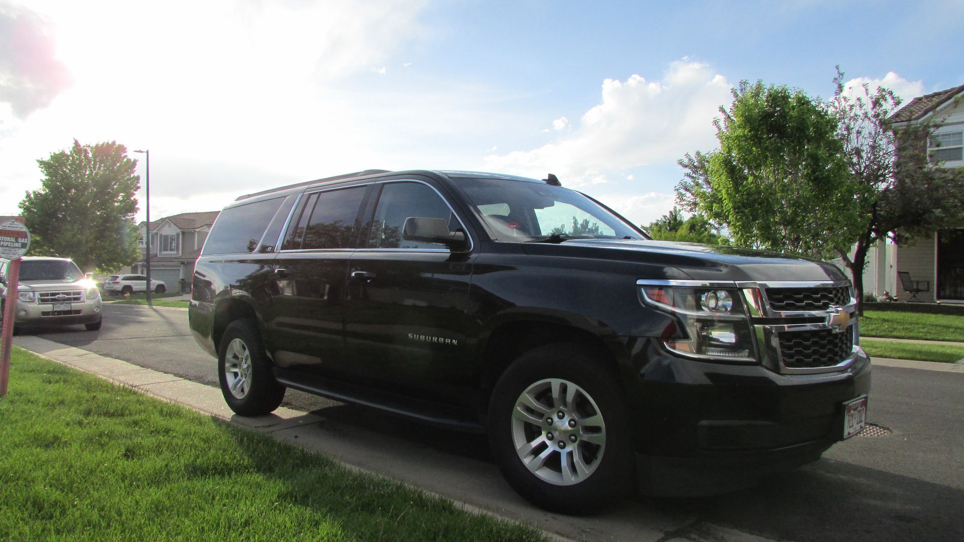 A black suv is parked on the side of the road.