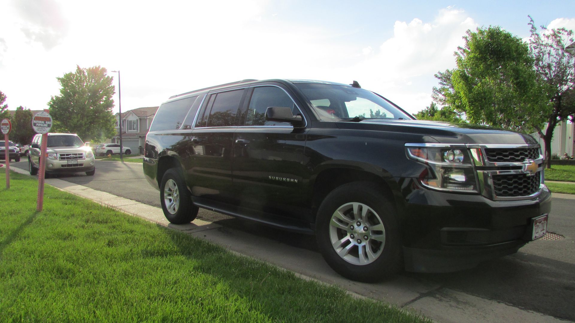 A black suv is parked on the side of the road.