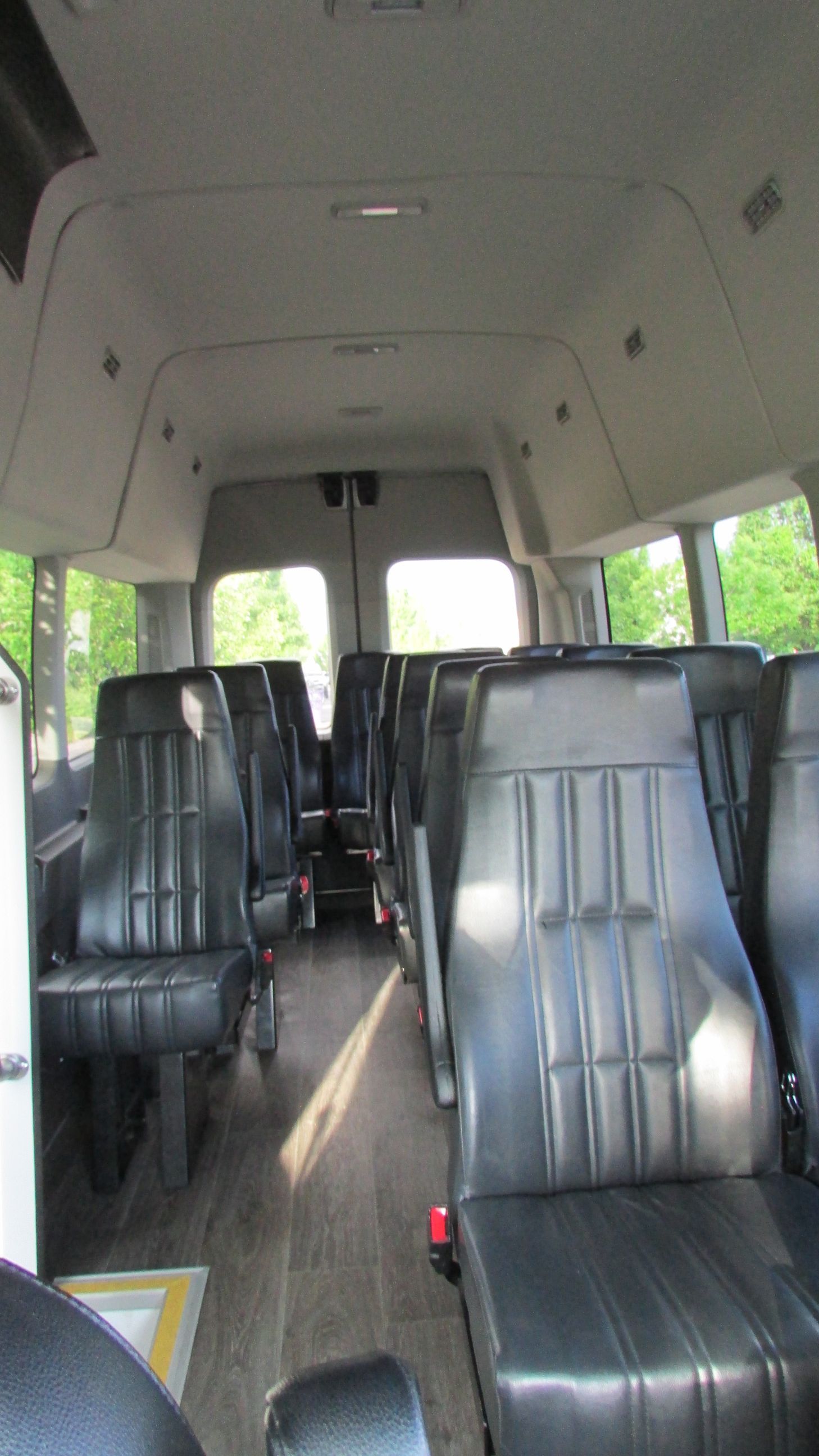 The inside of a van with lots of black seats.