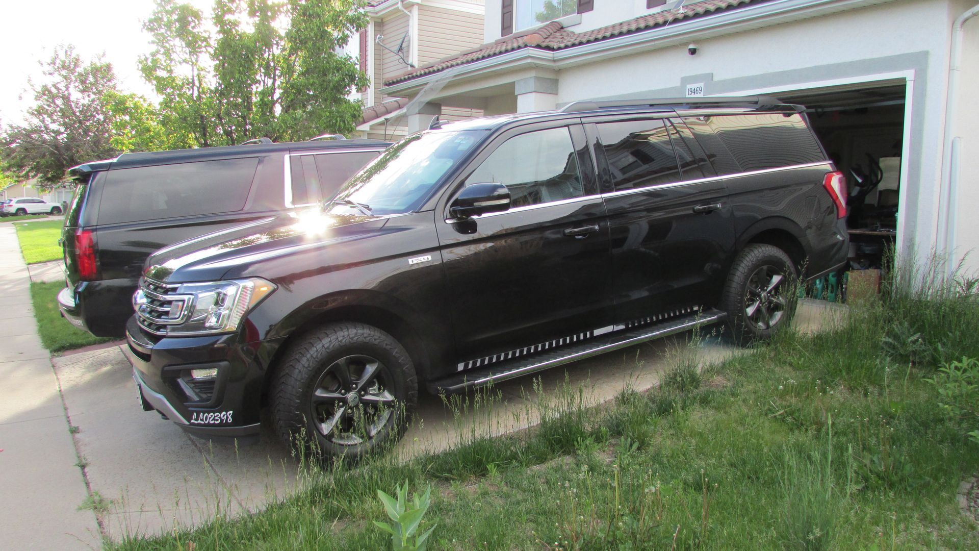 A black suv is parked in front of a garage.