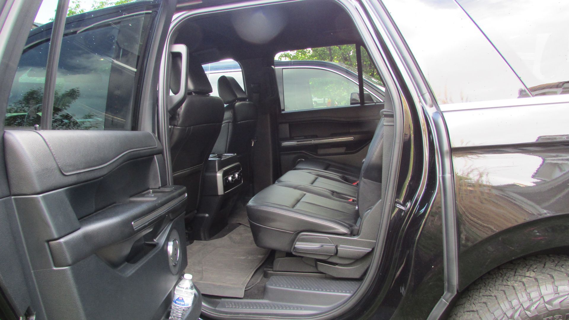 The back seat of a black suv with the door open.