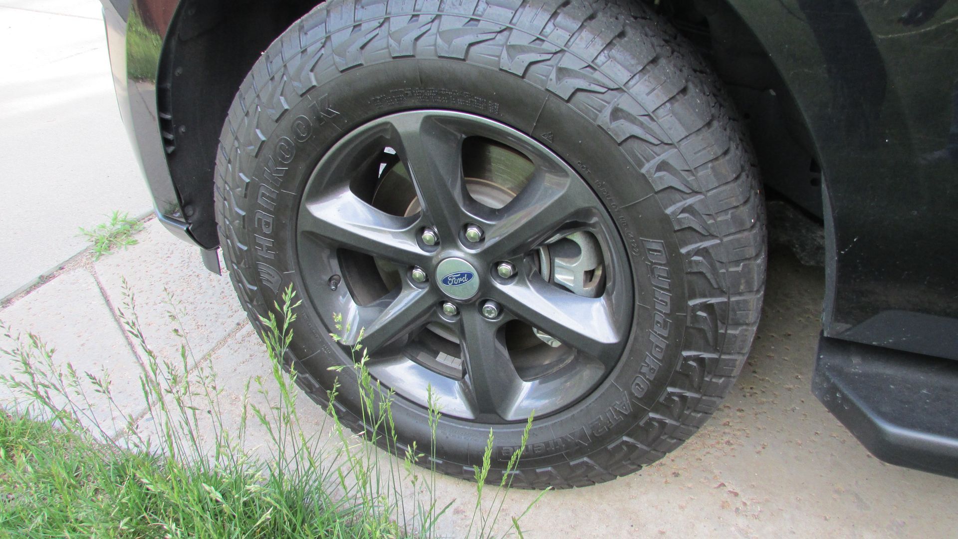 A close up of a tire on a black truck.