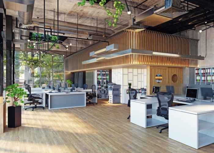 An empty, modern office space with light-colored walls, large windows, and a light-gray floor.
