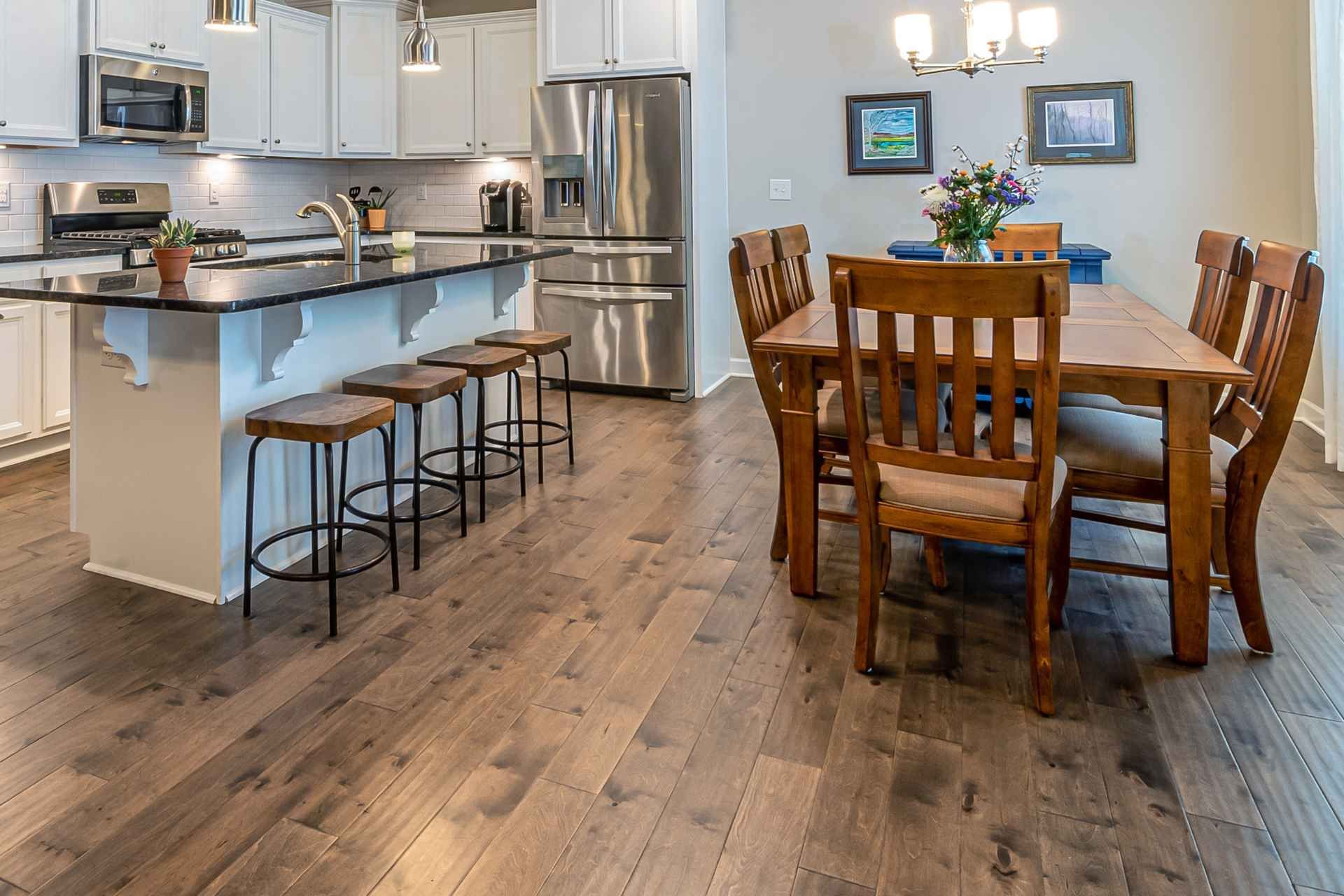 A bright and inviting kitchen and dining area with new floor, is captured in a well-lit photograph