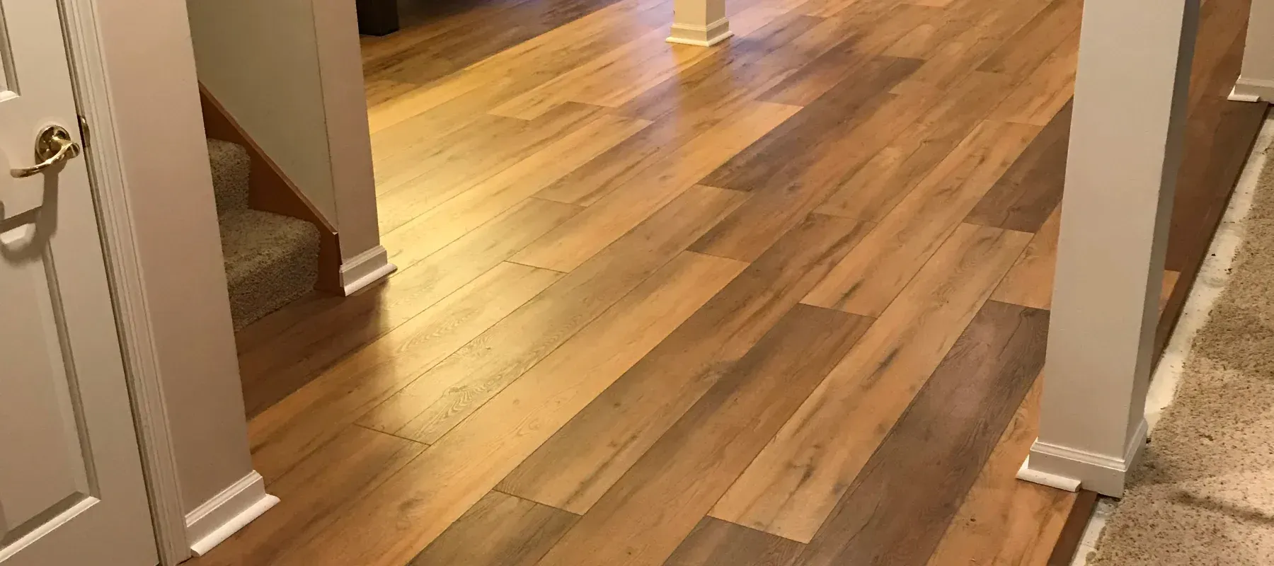 A hallway with hardwood floors and stairs in a house.