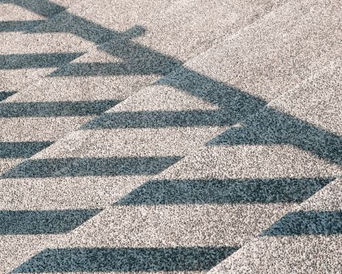 A close up of a carpet with a pattern of arrows on it.