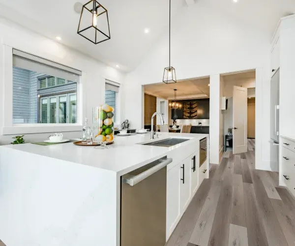 A kitchen with a large island , stainless steel appliances , and hardwood floors.