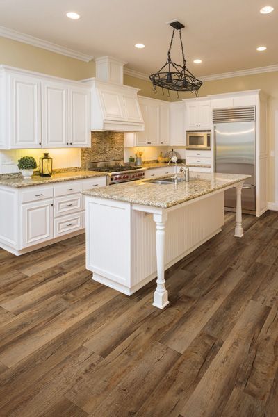 A kitchen with white cabinets and a large island in the middle.