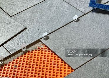 A close up of a tile floor being installed.