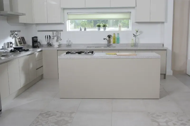 A kitchen with white cabinets and a large island in the middle.
