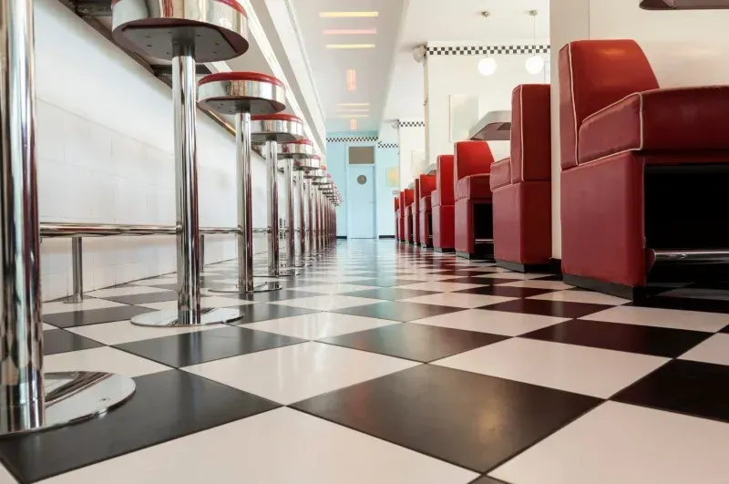A diner with a checkered floor and red chairs
