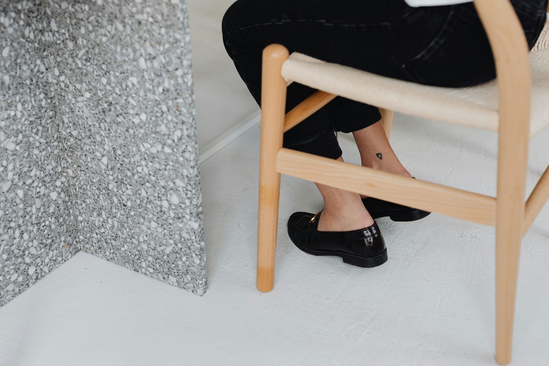 A woman is sitting in a chair with her legs crossed.