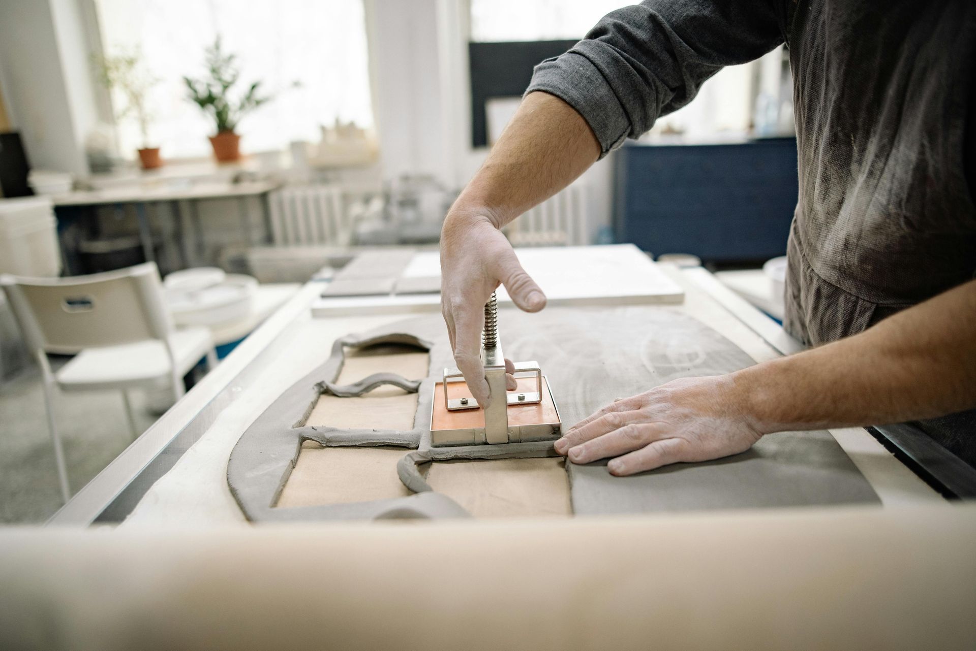 A man is working on a piece of clay on a table.