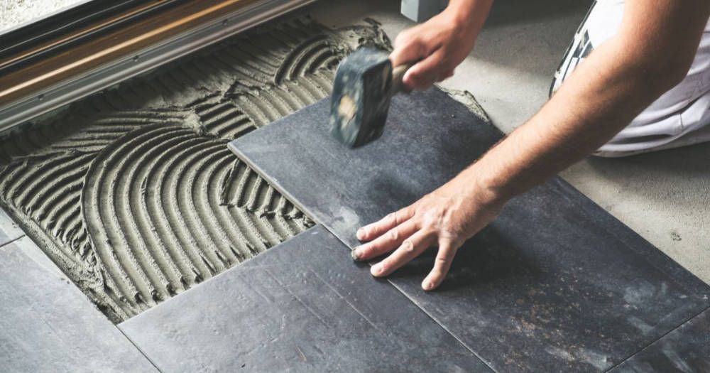 A close up of a tile floor being installed.