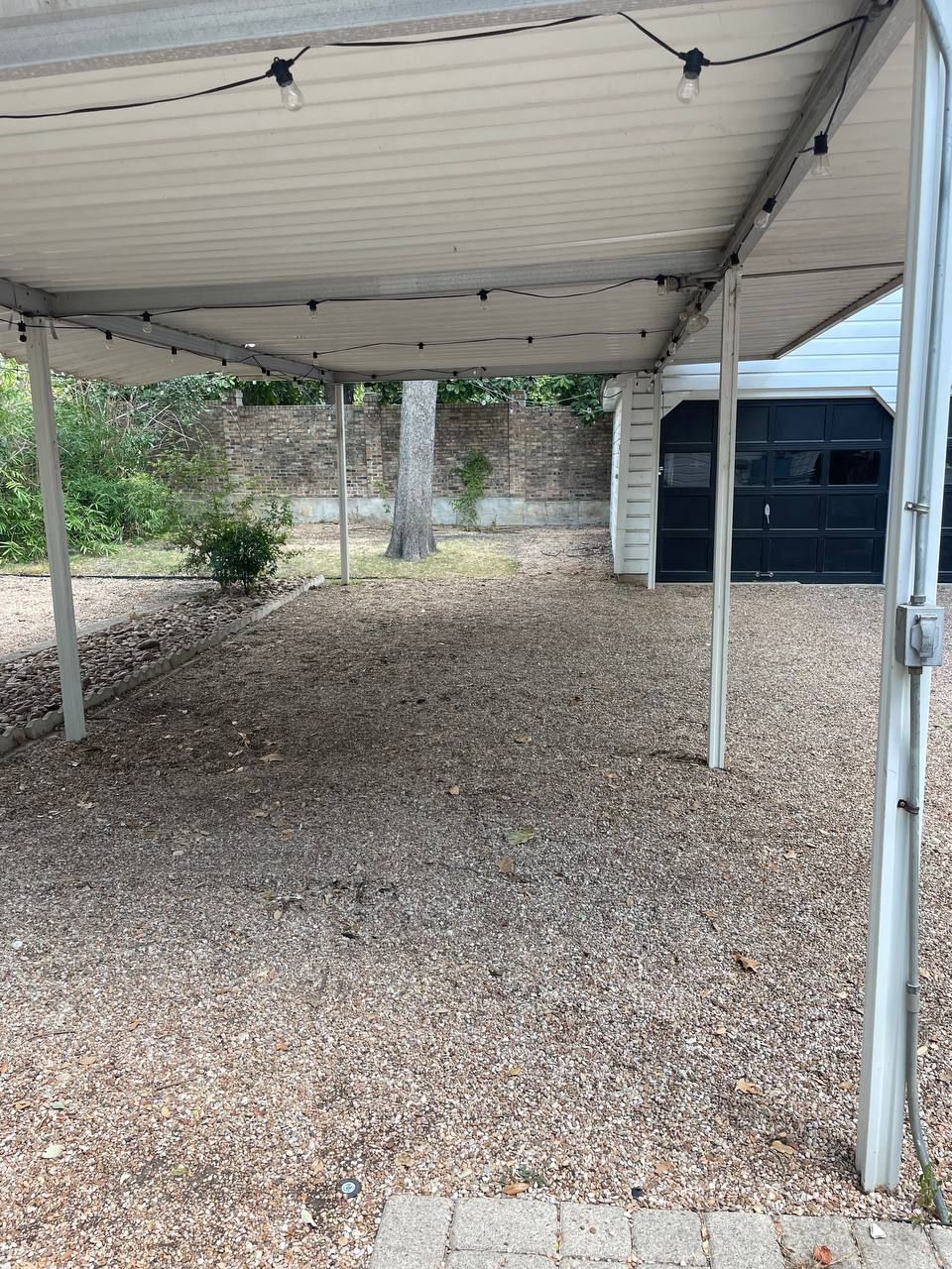 There is a carport in the backyard of a house.