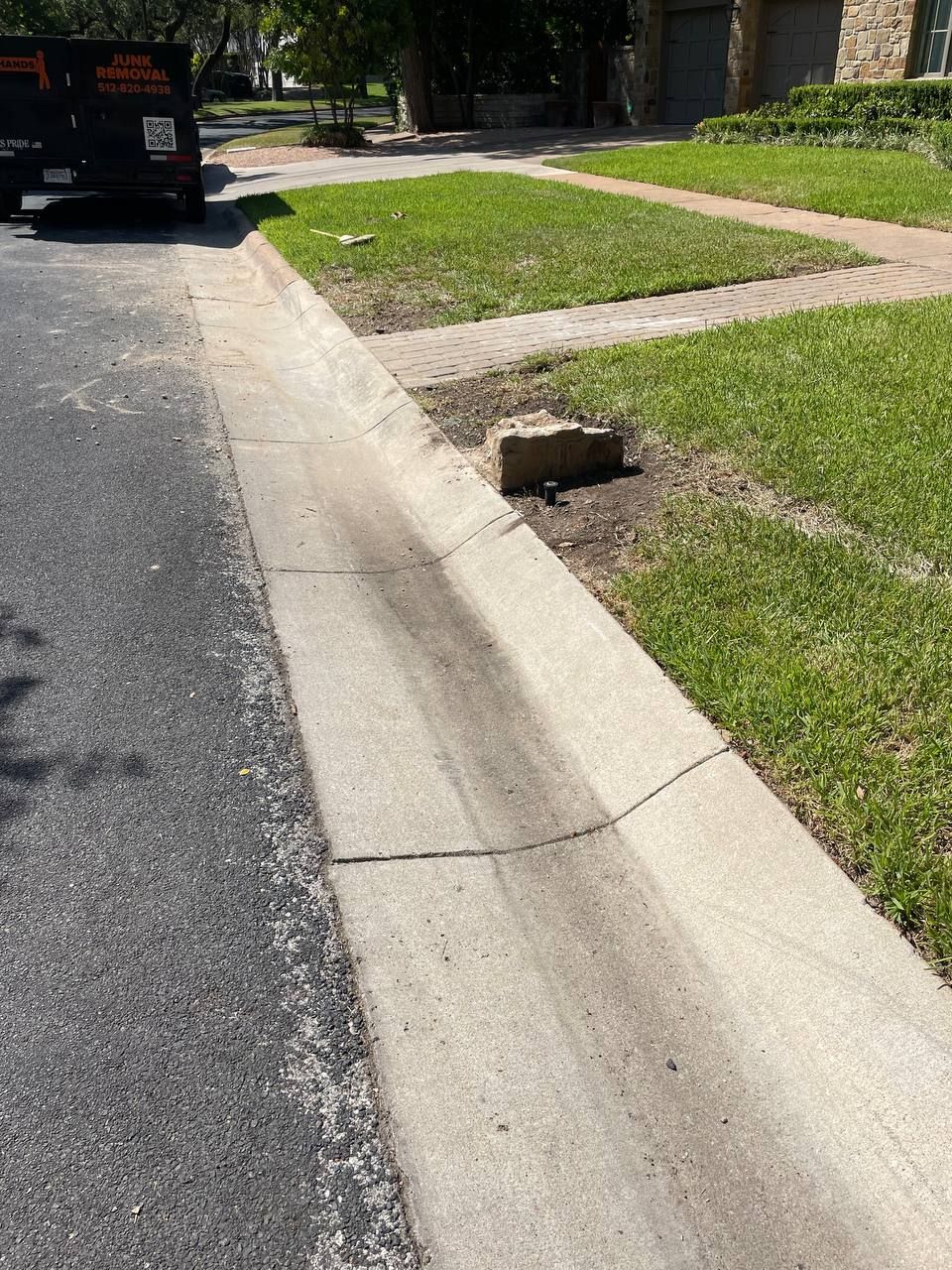 A black van is parked on the side of the road next to a curb.