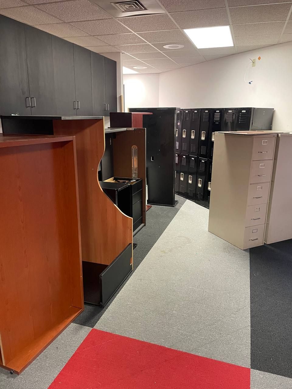 A room with a lot of lockers and a red carpet.