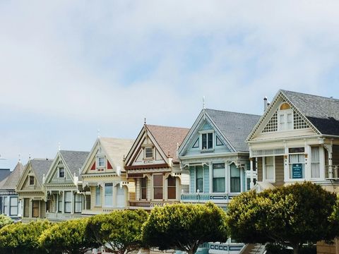 A row of houses with trees in front of them