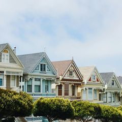 A row of houses with trees in front of them