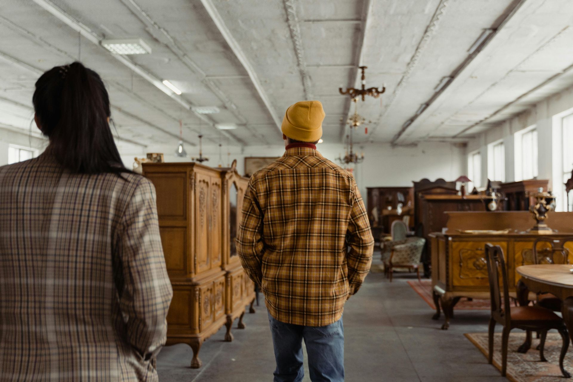 A man and a woman are looking at furniture in a store.