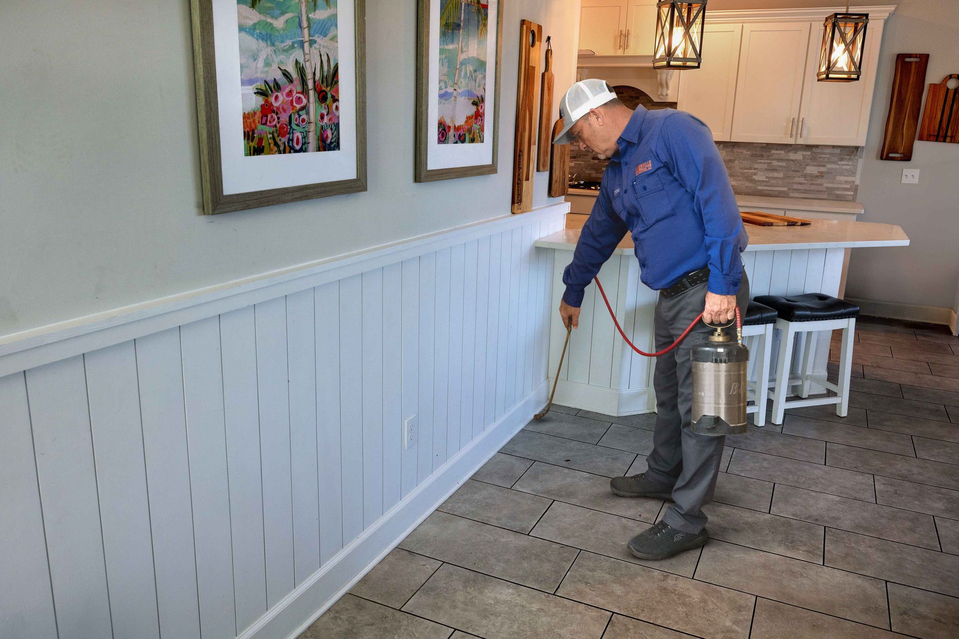 A man is spraying a room with a spray bottle.