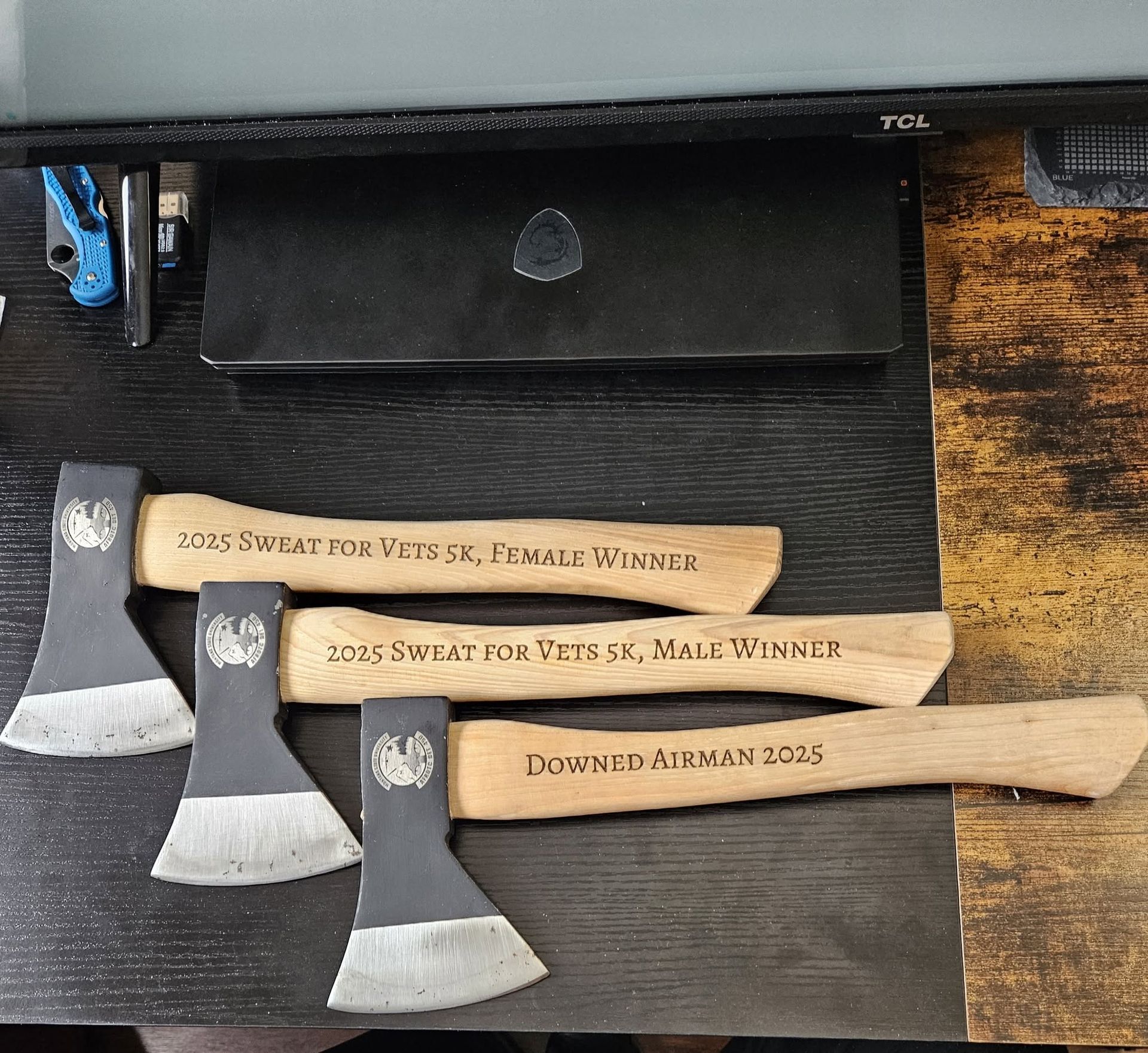 Laser cutter engraving a wooden panel with a swirling floral pattern