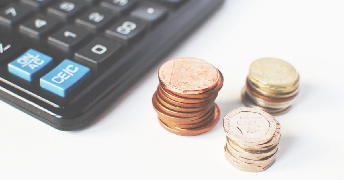 Three stacks of coins are sitting next to a calculator.