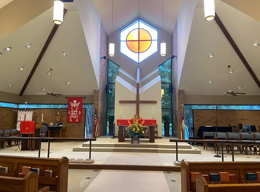 The inside of a church with a cross on the altar
