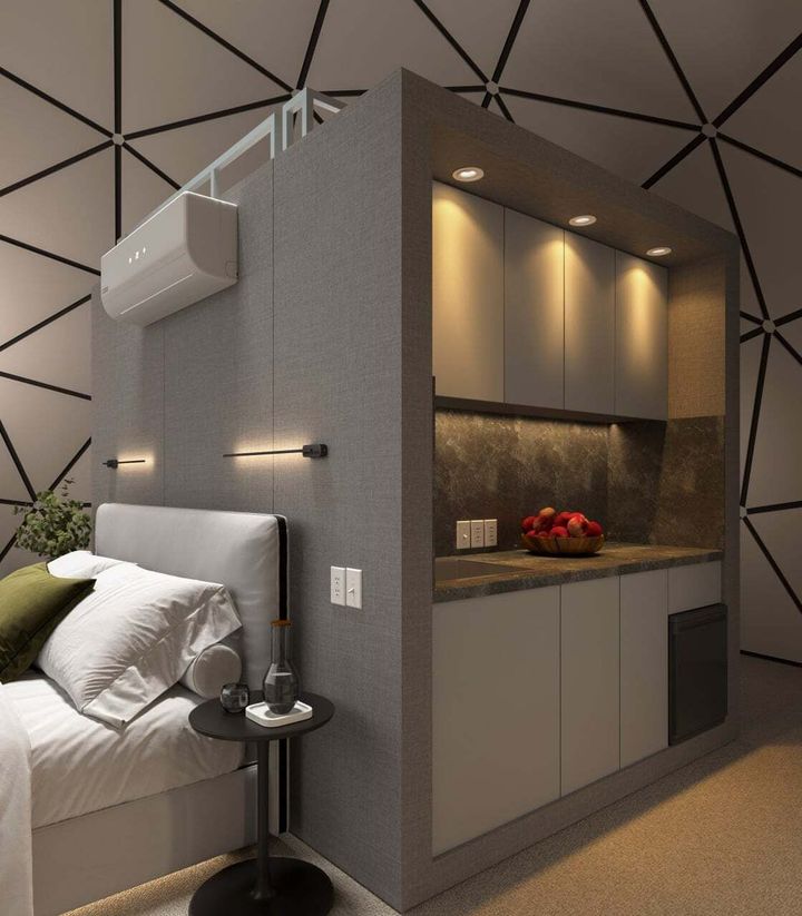 Modern bedroom with a built-in gray alcove, warm recessed lights, and a small bedside table