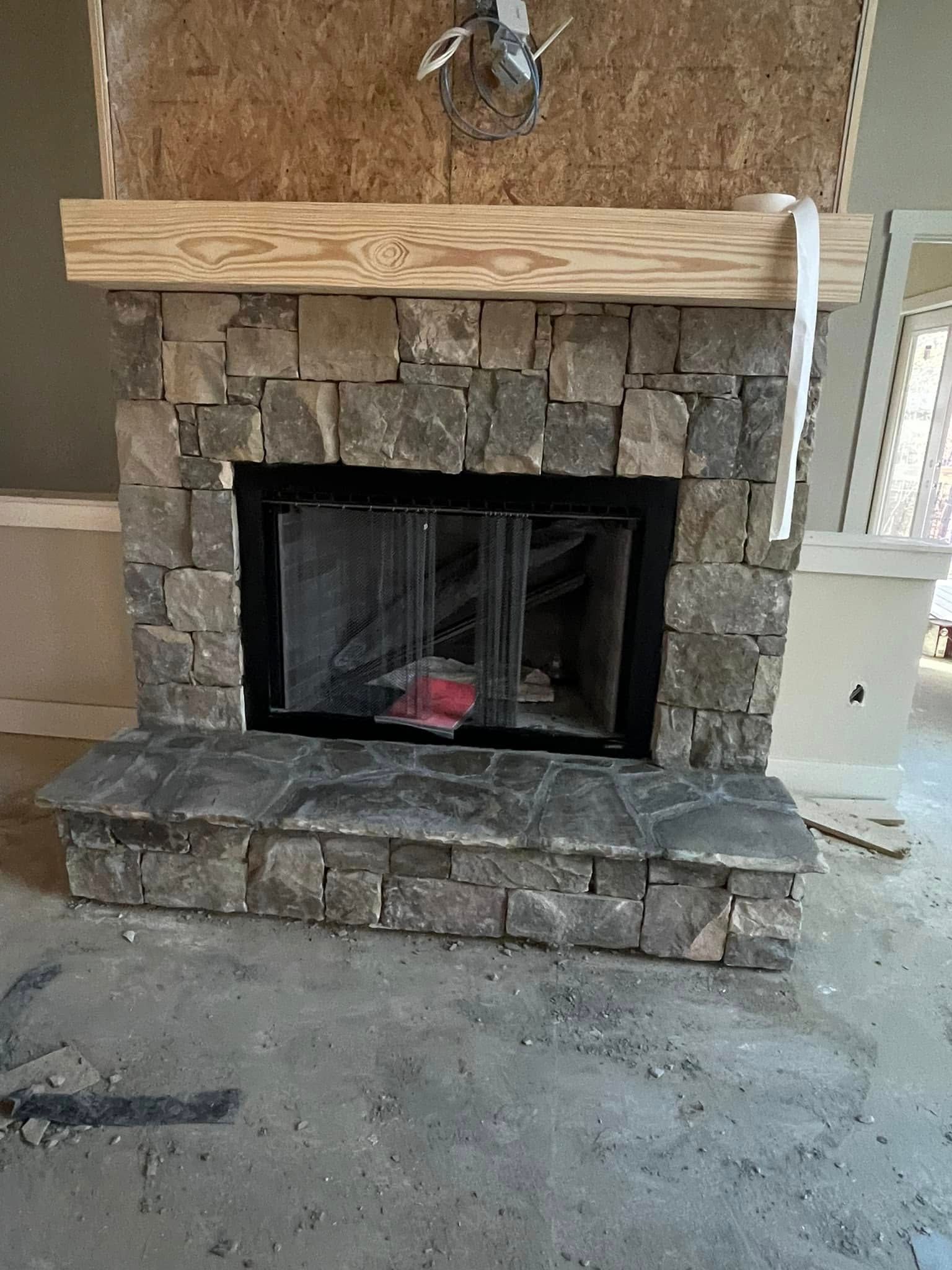 Woman in straw hat smiles, holding wine glass near a lake.