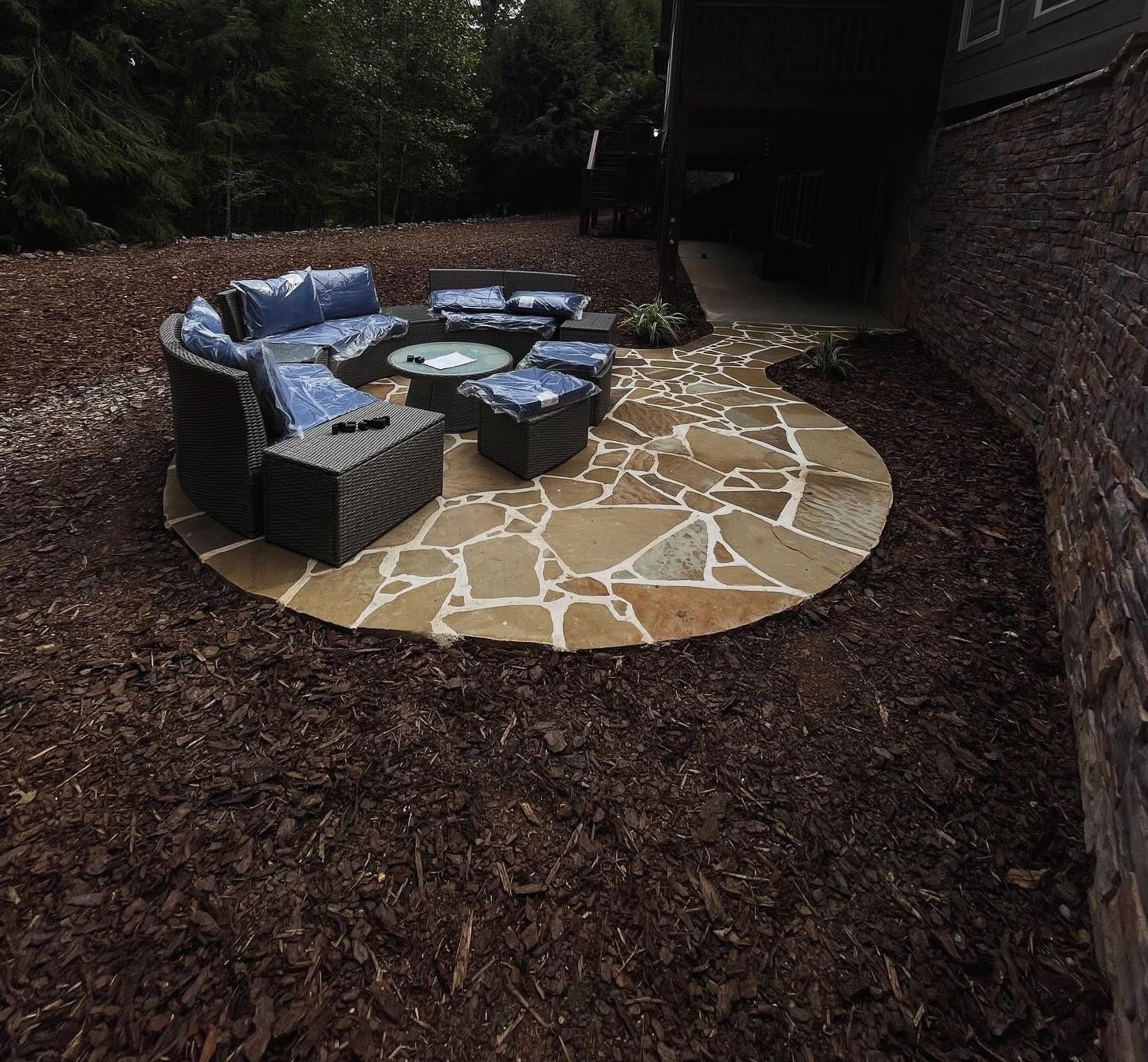 Woman in straw hat smiles, holding wine glass near a lake.