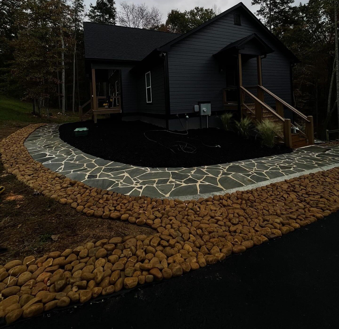 Woman in straw hat smiles, holding wine glass near a lake.
