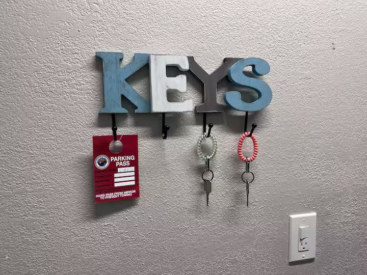 A key holder with the word keys hanging on a wall.