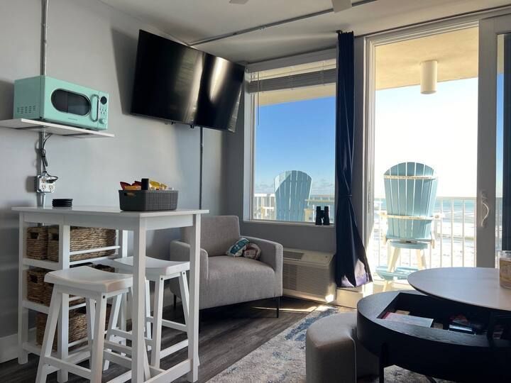 A living room with a couch , table , chairs and a television.