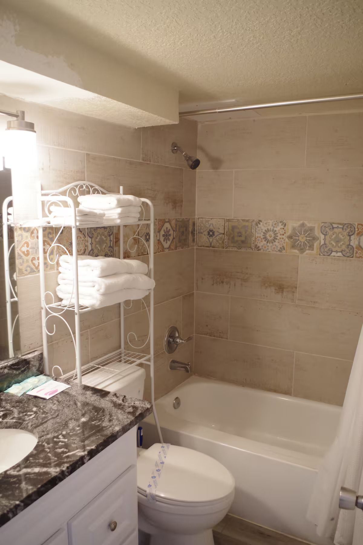 A bathroom with a toilet , sink , tub and shower.