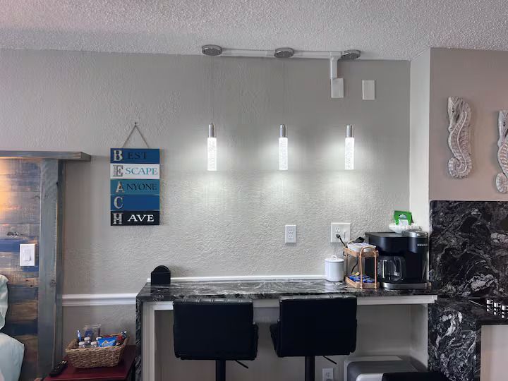 A kitchen with a sign on the wall that says be safe and have