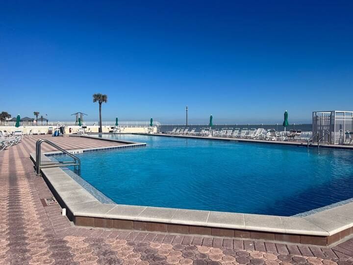 A large swimming pool with palm trees in the background
