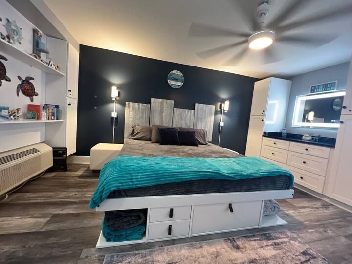 A bedroom with a large bed and a ceiling fan.