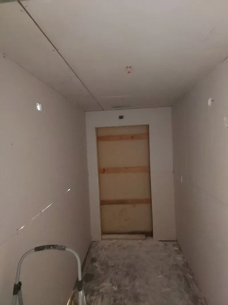 A room with a door and a ladder in it.