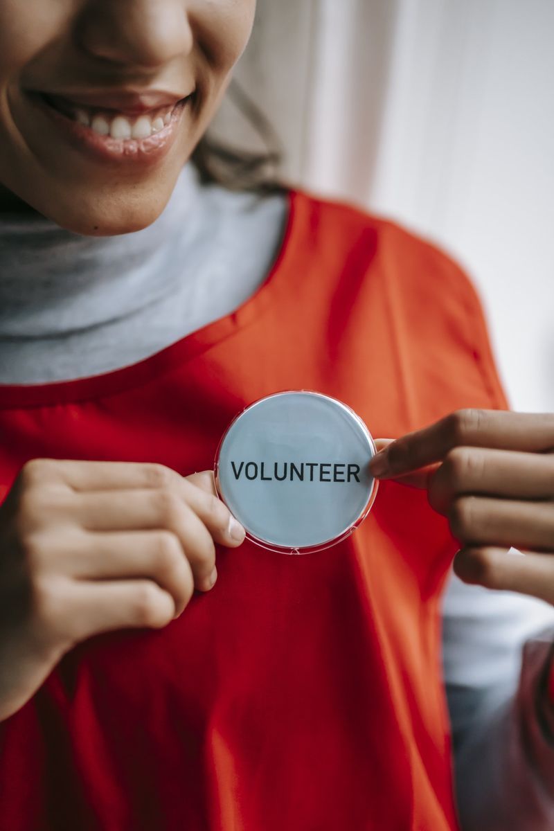 A woman is holding a volunteer badge in her hands.