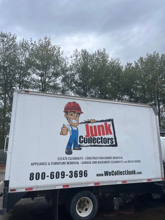 A junk collectors truck is parked in a parking lot.