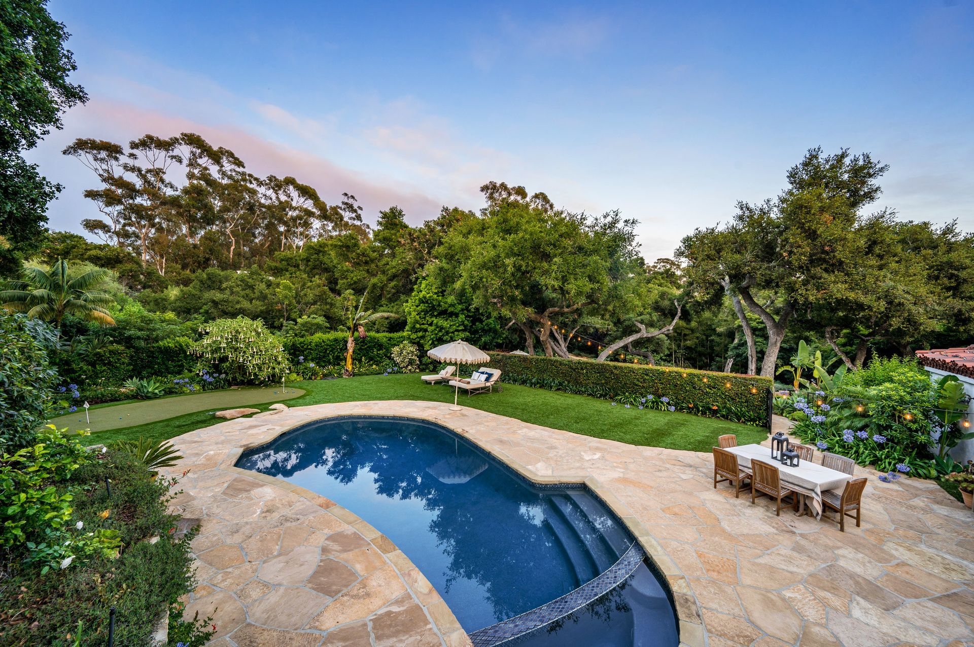 There is a large swimming pool in the middle of the backyard.