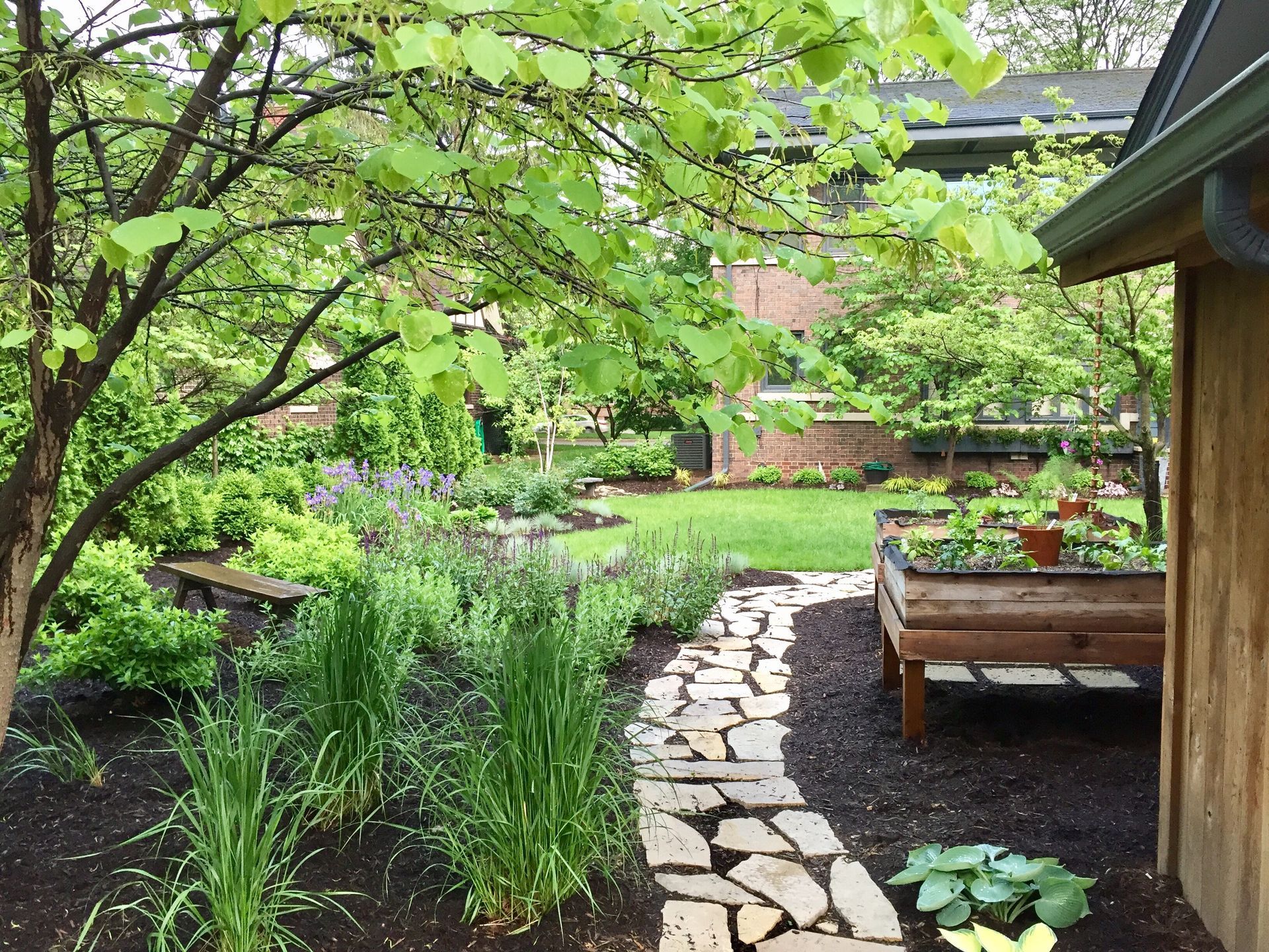 A stone path leading to a wooden shed in a garden.