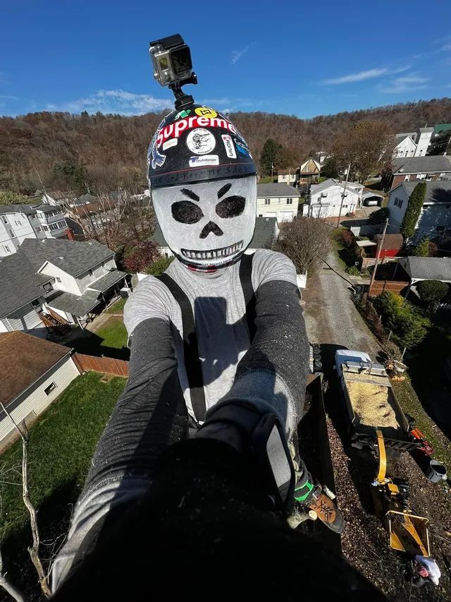A person wearing a skull mask and a helmet is taking a selfie.